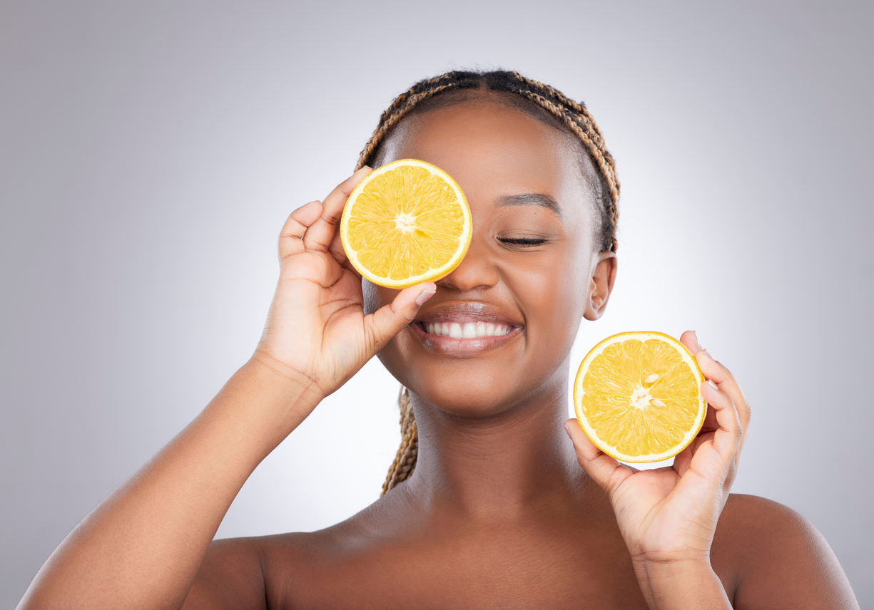 Studio shot of an attractive young woman holding a sliced orange against a grey background Pleasure spiked with zest