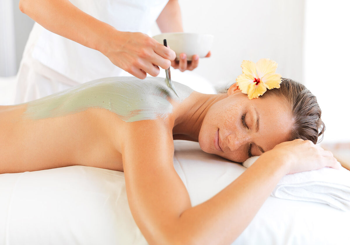 Relaxed young woman receiving a skincare beauty treatment on her back at a spa